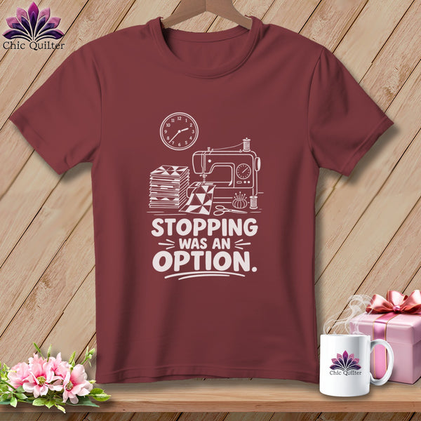 Maroon t-shirt with sewing machine, fabric, and text "STOPPING WAS AN OPTION".