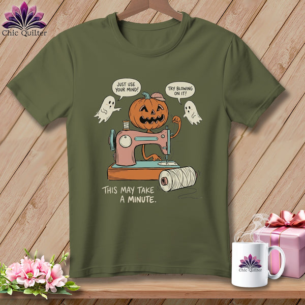 Pumpkin on sewing machine with ghosts and text "This may take a minute."