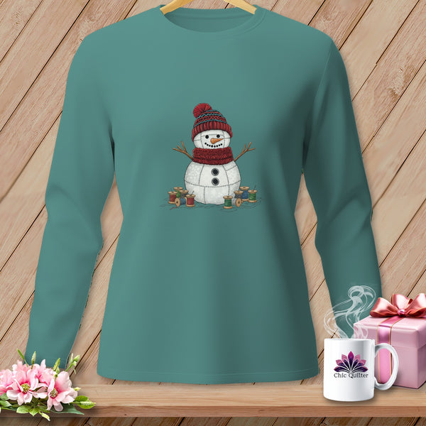 Teal long-sleeve shirt with a stitched snowman graphic and spools of thread.