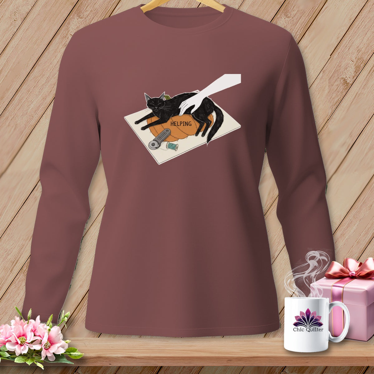 Brown long-sleeved shirt with a graphic of a black cat on a pumpkin labeled "HELPING."