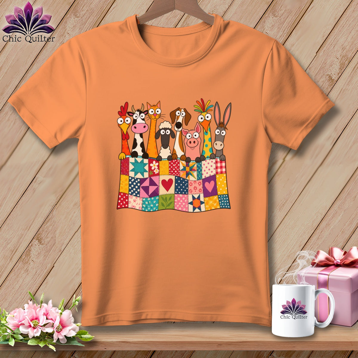 An orange t-shirt displays a graphic of cartoon farm animals peeking over a colorful patchwork quilt.