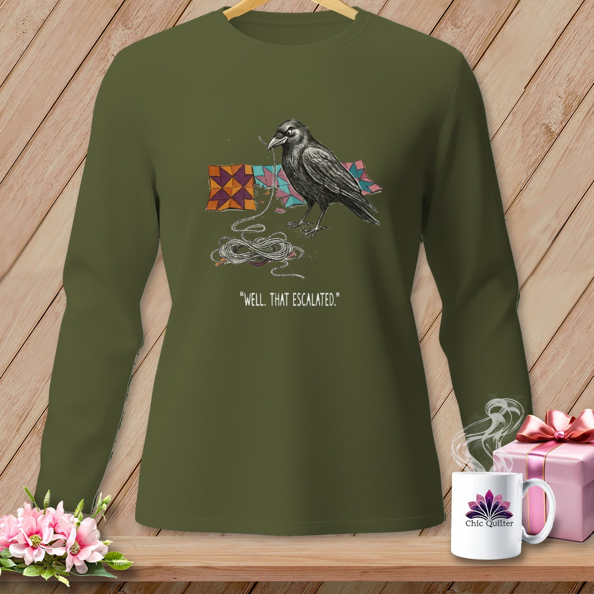 Green long-sleeve shirt with a crow perched on quilting fabric and the text "Well. That Escalated."