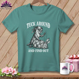 Teal crewneck t-shirt featuring a graphic of an otter sewing a rabbit into a patchwork quilt with the text TUCK AROUND AND FIND OUT.