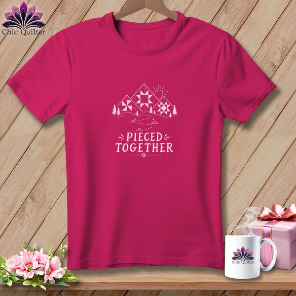 Pink t-shirt with white graphic of mountains and text "Pieced Together".