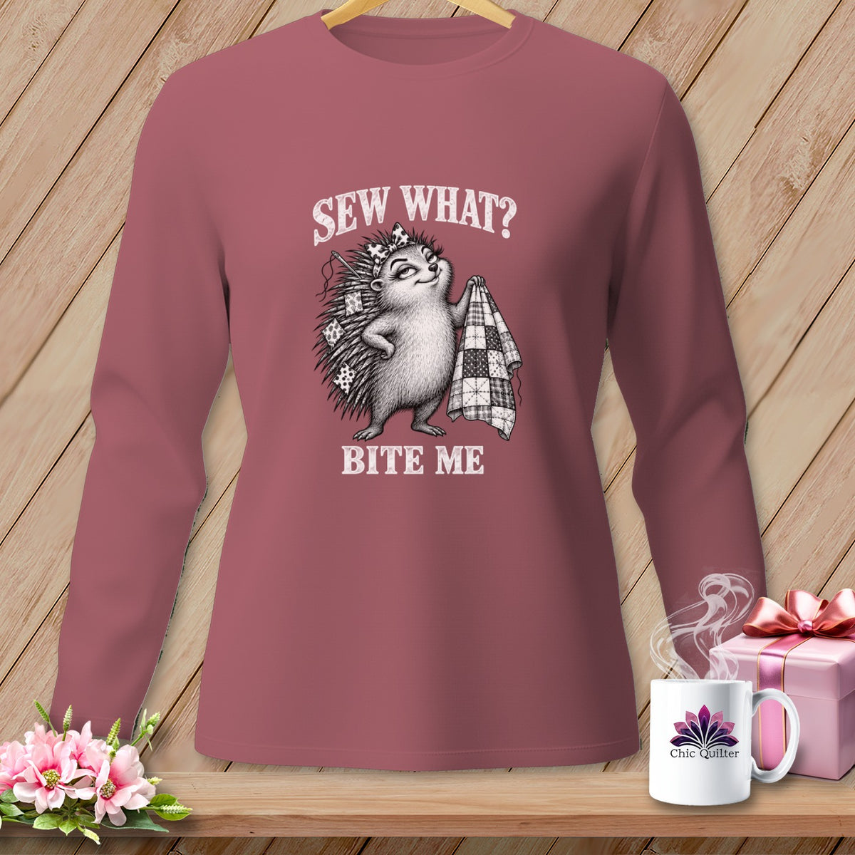 Dusty rose long-sleeved shirt featuring a hedgehog graphic with the text Sew What? Bite Me.