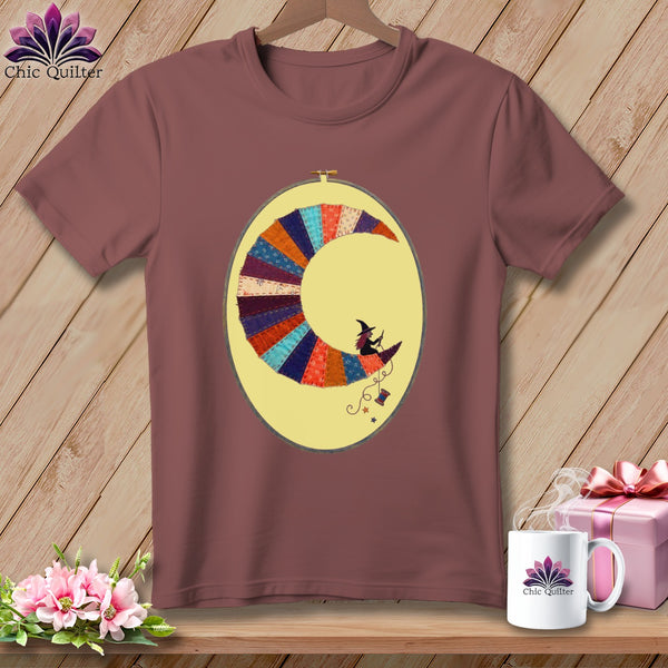T-shirt featuring a moon made of colorful patchwork with a witch riding a broom.