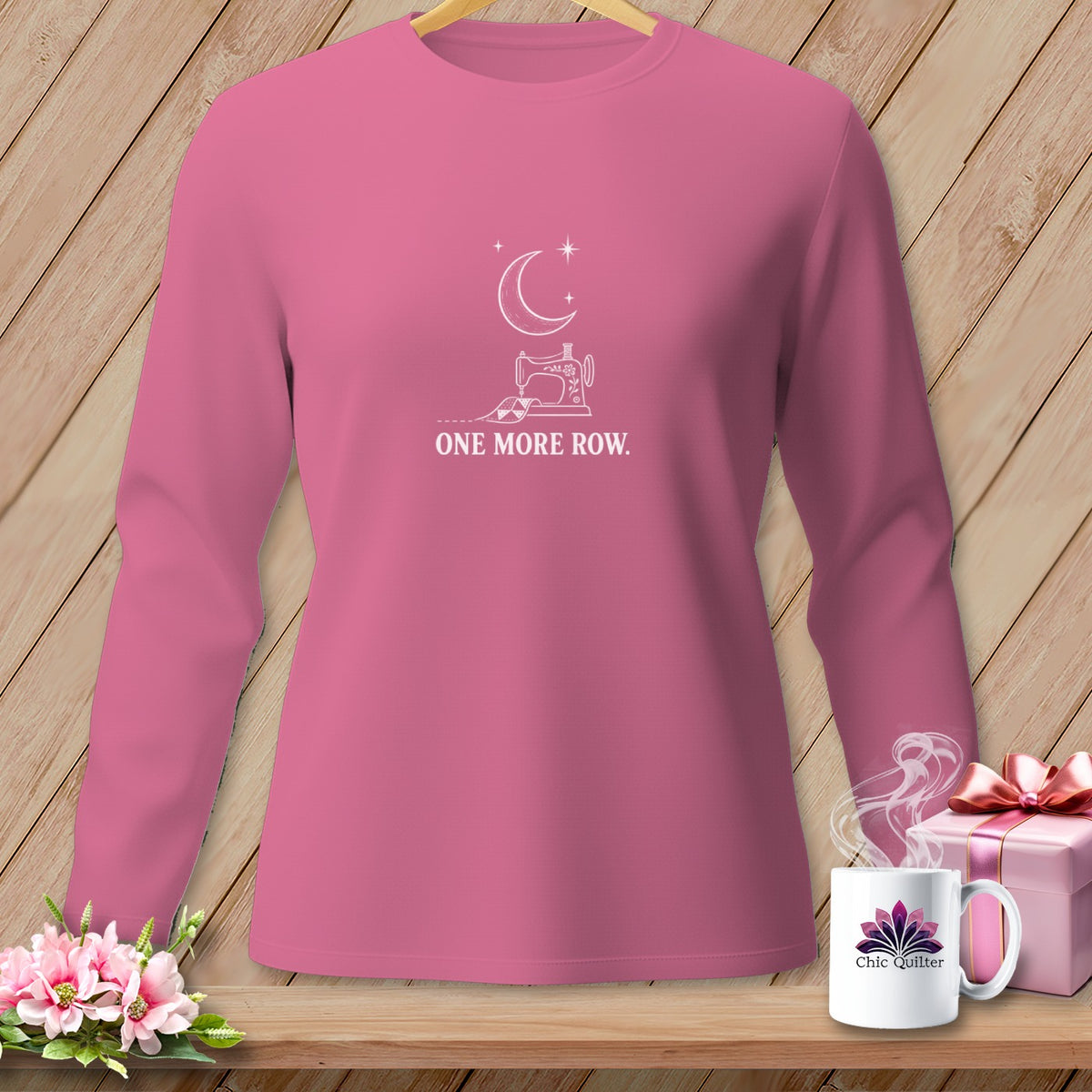 Pink long-sleeve shirt with moon, sewing machine, and "ONE MORE ROW" text.