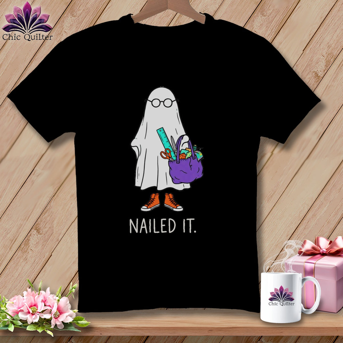 Black t-shirt with a ghost wearing glasses and carrying a bag of craft supplies.