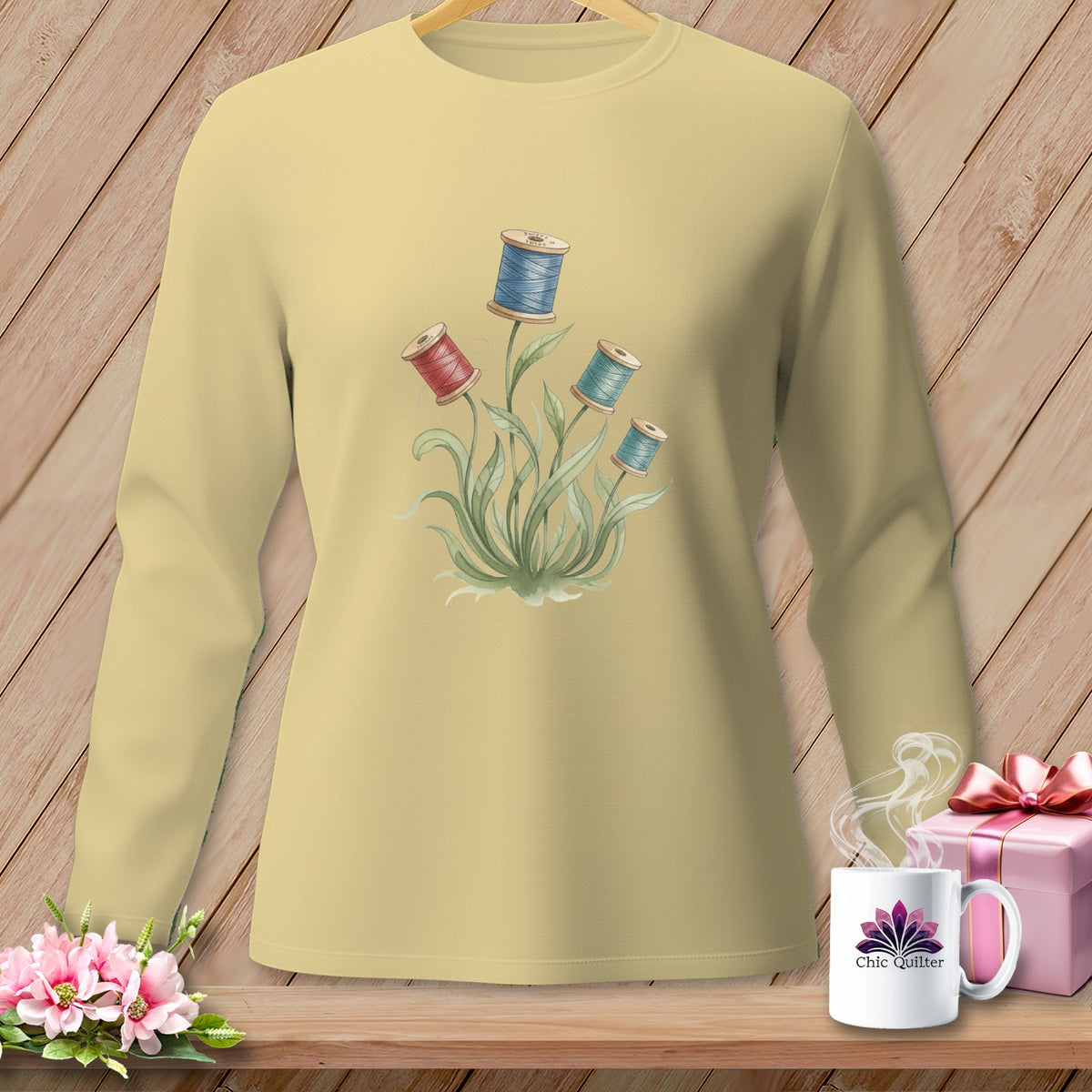 Yellow long-sleeved shirt with a watercolor floral design of spools of thread.