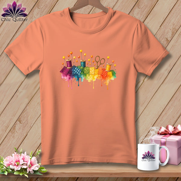 Peach t-shirt with watercolor sewing notions and rainbow patchwork quilt squares.