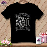Black t-shirt featuring a Las Vegas Quilter graphic with folded quilts, a measuring tape, coffee cup, and the number 10.