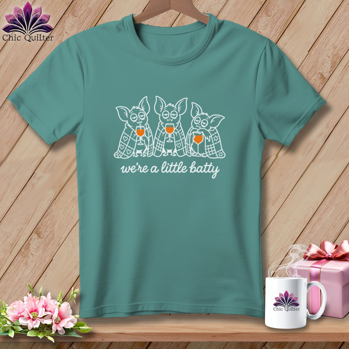 Teal t-shirt with three bats holding wine glasses, text "we're a little batty".