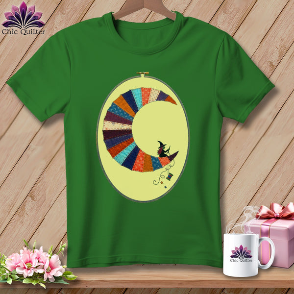 Green t-shirt with a crescent moon made of colorful fabric scraps featuring a witch.