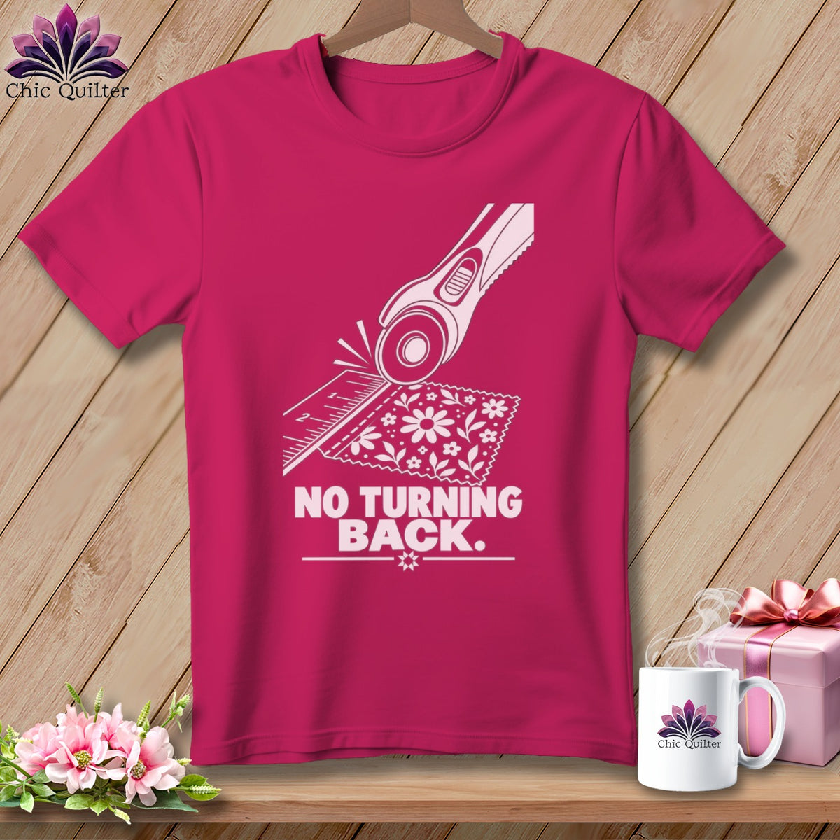 Fuchsia t-shirt with rotary cutter, ruler, fabric, and text "NO TURNING BACK."