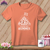 Peach t-shirt with white graphic: stacked quilts, flag, mountains, and text.