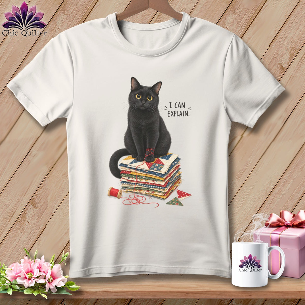 Black cat sits on quilt squares with thread, saying "I CAN EXPLAIN."