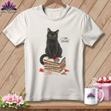 Black cat sits on quilt squares with thread, saying 