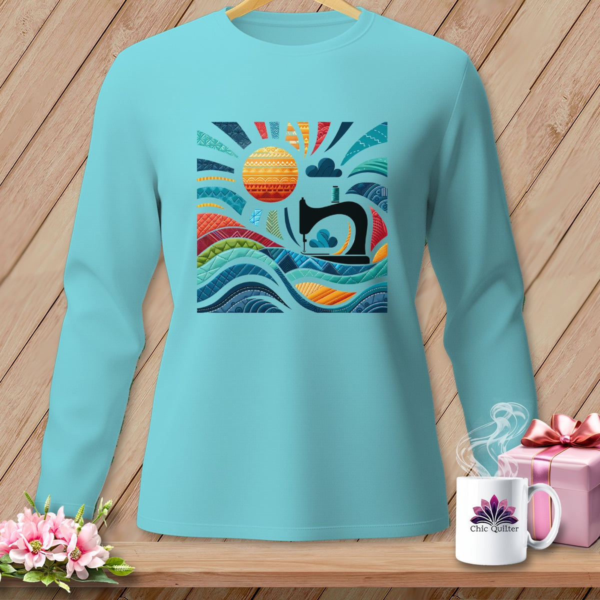 Aqua long-sleeve shirt with sewing machine and abstract sun graphic.