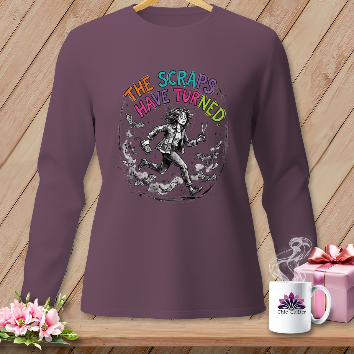 Long sleeve shirt with graphic: "The Scraps Have Turned" and a running figure with scissors.