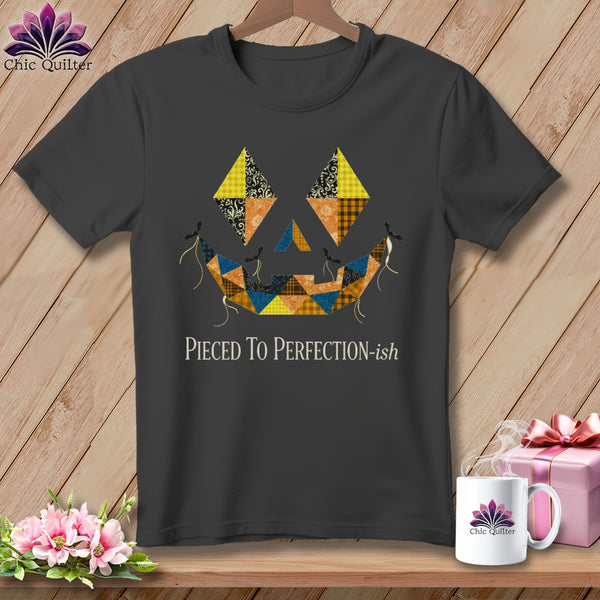 Dark gray t-shirt with a patchwork jack-o'-lantern face and text "Pieced To Perfection-ish".