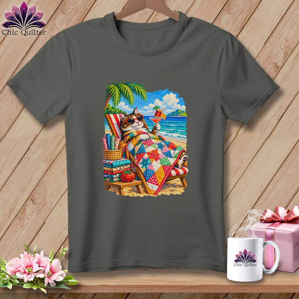 Charcoal gray t-shirt featuring a graphic of a cat relaxing in a beach chair with a colorful quilt.