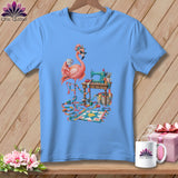 Blue t-shirt with a flamingo sewing on a miniature quilt.
