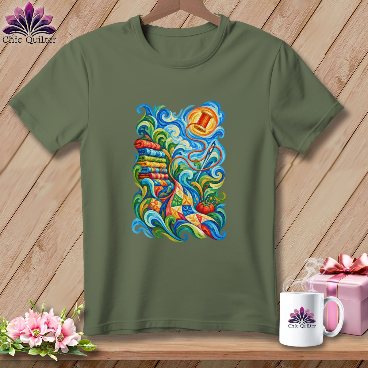 An olive green crewneck t-shirt featuring a colorful quilting-themed graphic on the chest.
