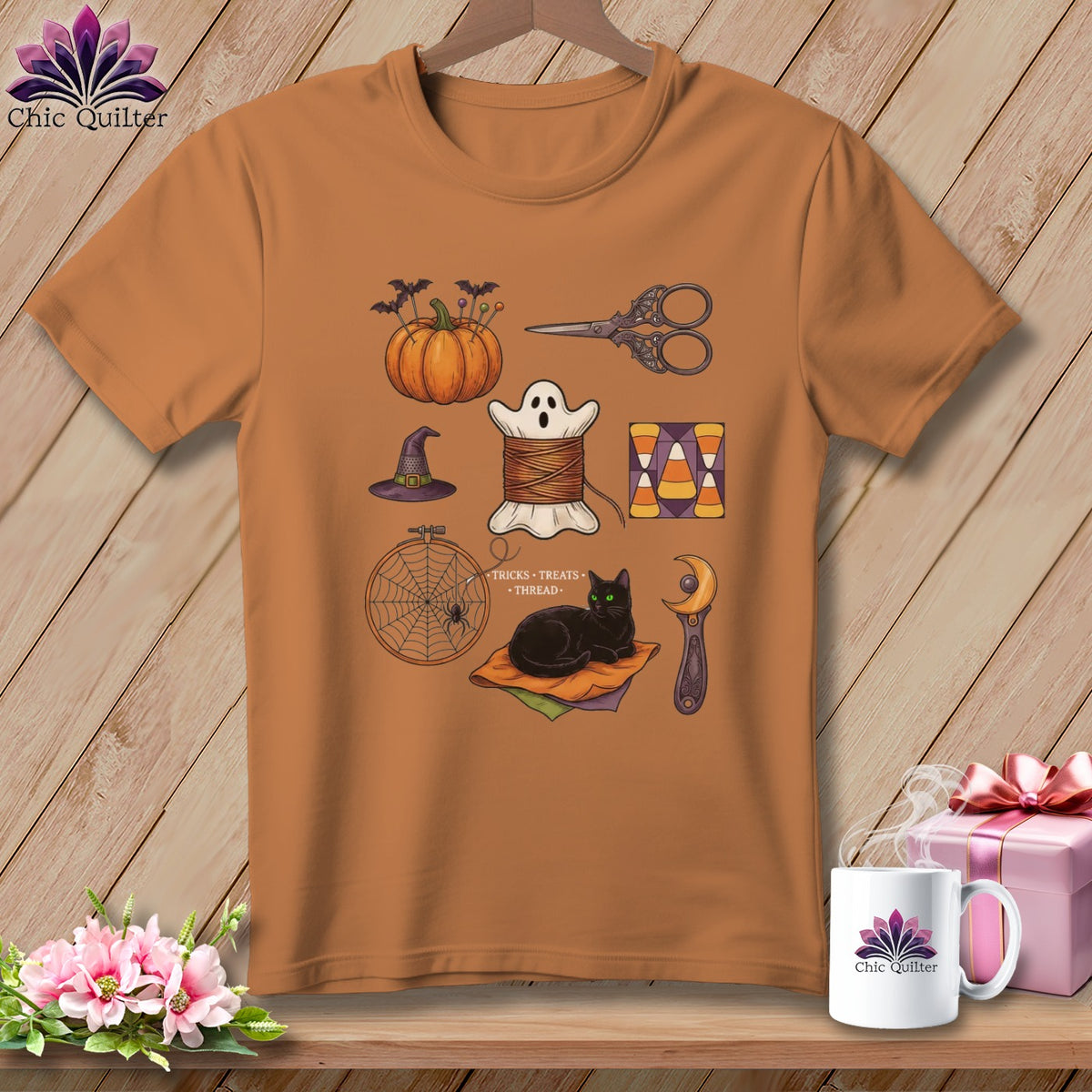 Orange t-shirt with Halloween sewing and quilting graphic featuring a pumpkin, ghost, cat, and more.