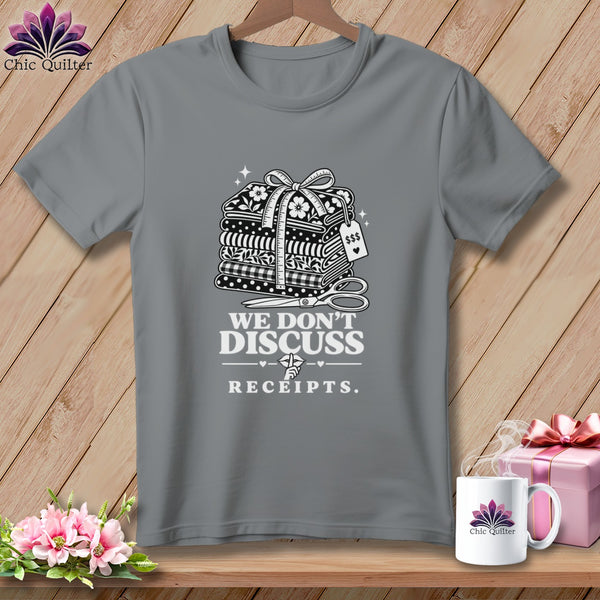 Grey t-shirt with stacked fabric, scissors, and text "WE DON'T DISCUSS RECEIPTS."