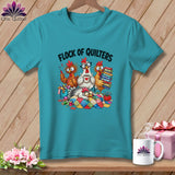 A turquoise t-shirt with a cartoon graphic of four chickens quilting, captioned Flock of Quilters.