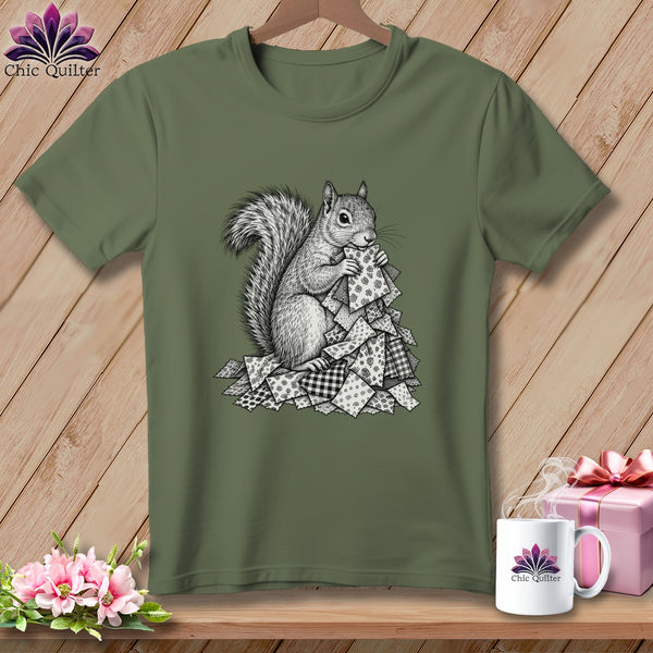 Olive green t-shirt featuring a black and white illustration of a squirrel holding a pile of patterned quilt squares.