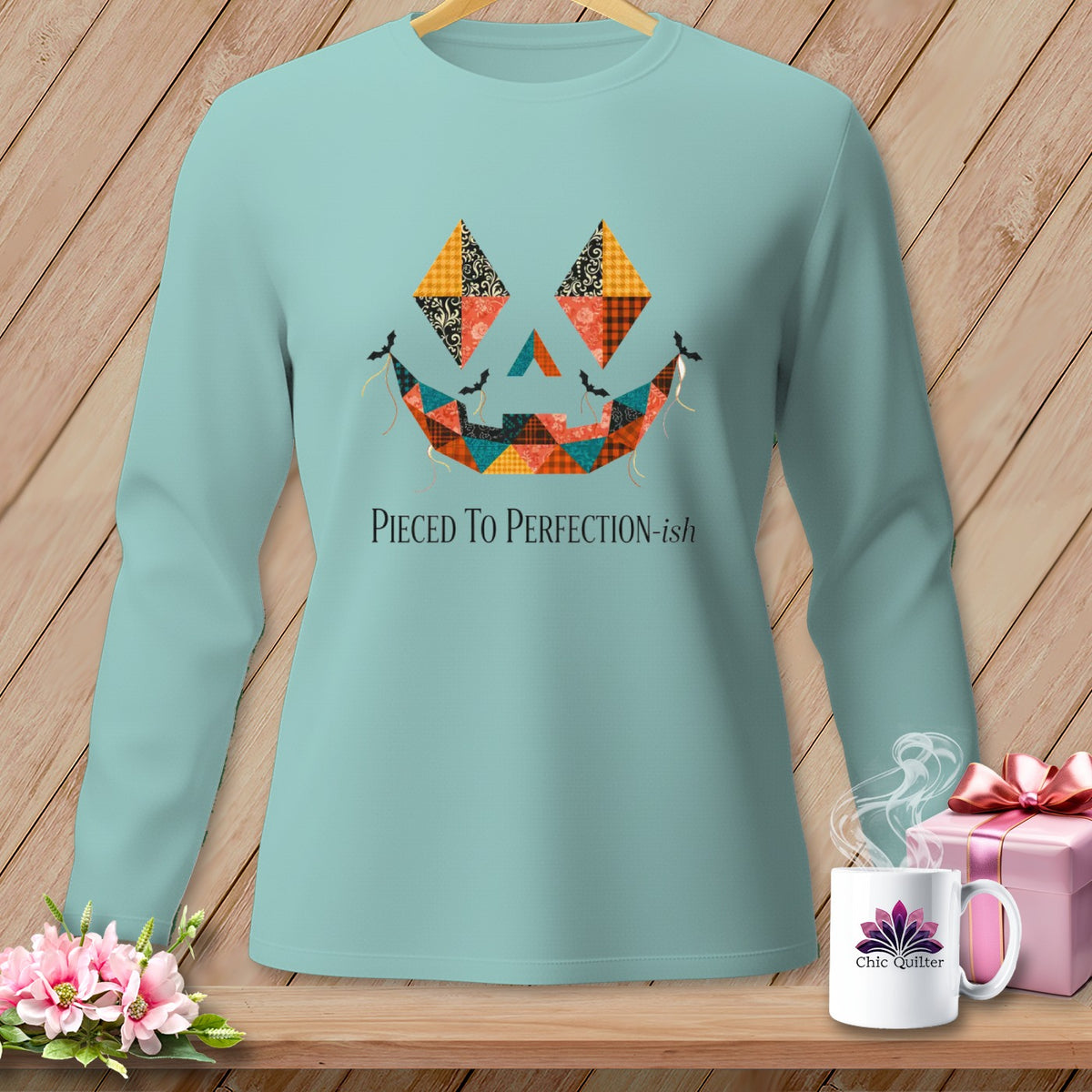 Light blue long-sleeve shirt with quilted jack-o'-lantern face and "Pieced To Perfection-ish" text.