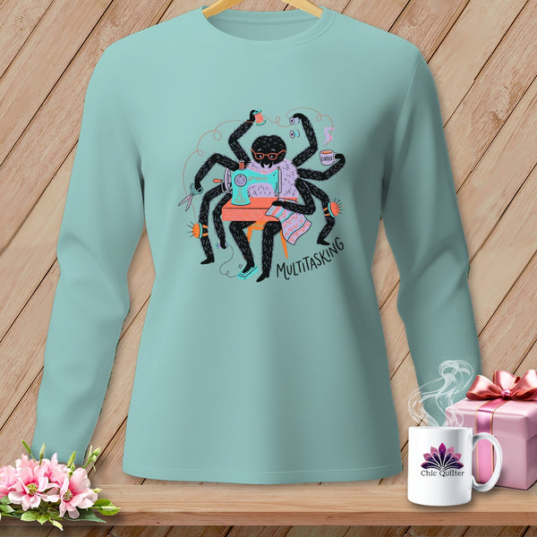 Spider sewing and drinking coffee with "MULTITASKING" text on a light blue long-sleeve shirt.