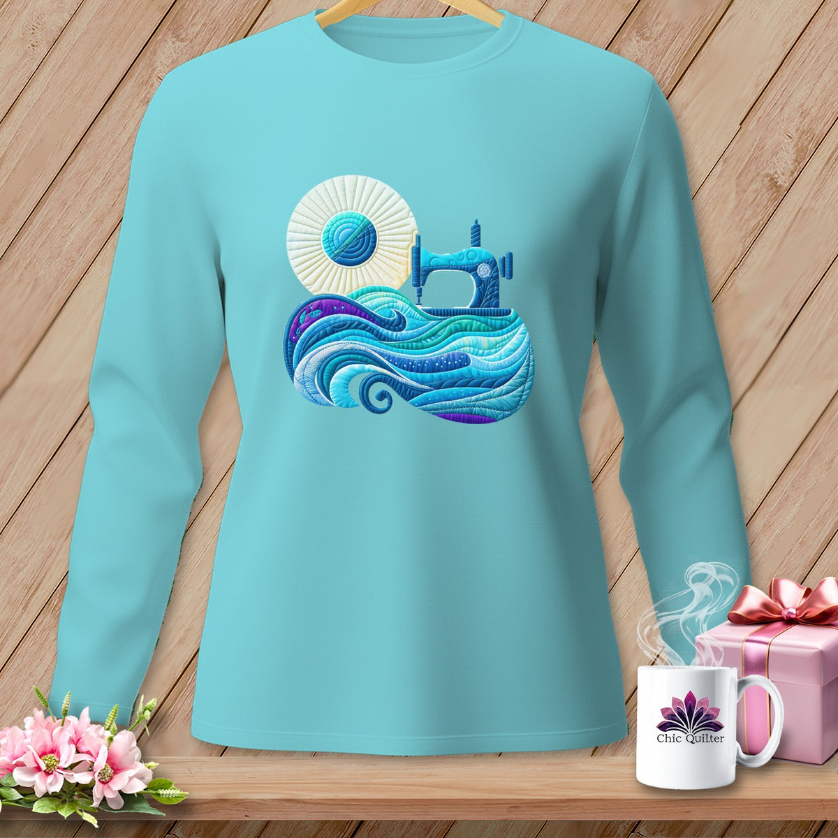 Aqua long sleeve shirt with a sewing machine and yarn quilt design.