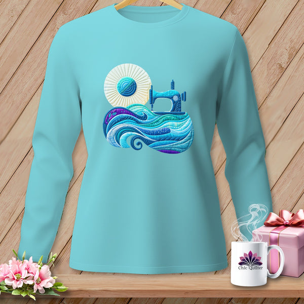 Aqua long sleeve shirt with a sewing machine and yarn quilt design.