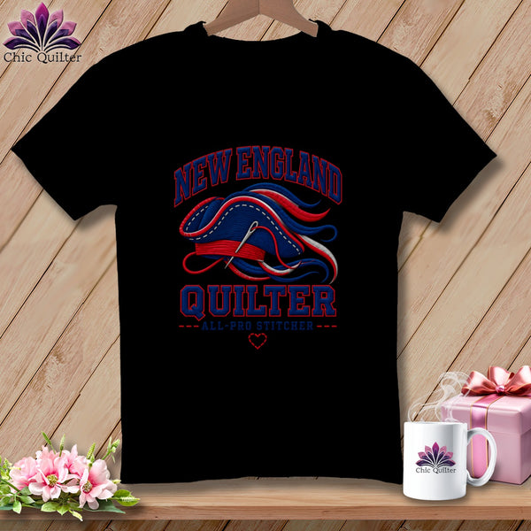 Black t-shirt featuring a New England Quilter graphic with a needle, thread, and heart design.