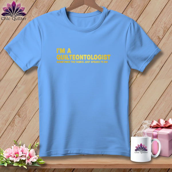 Light blue t-shirt with yellow text "I'M A QUILTEONTOLOGIST" and smaller text.