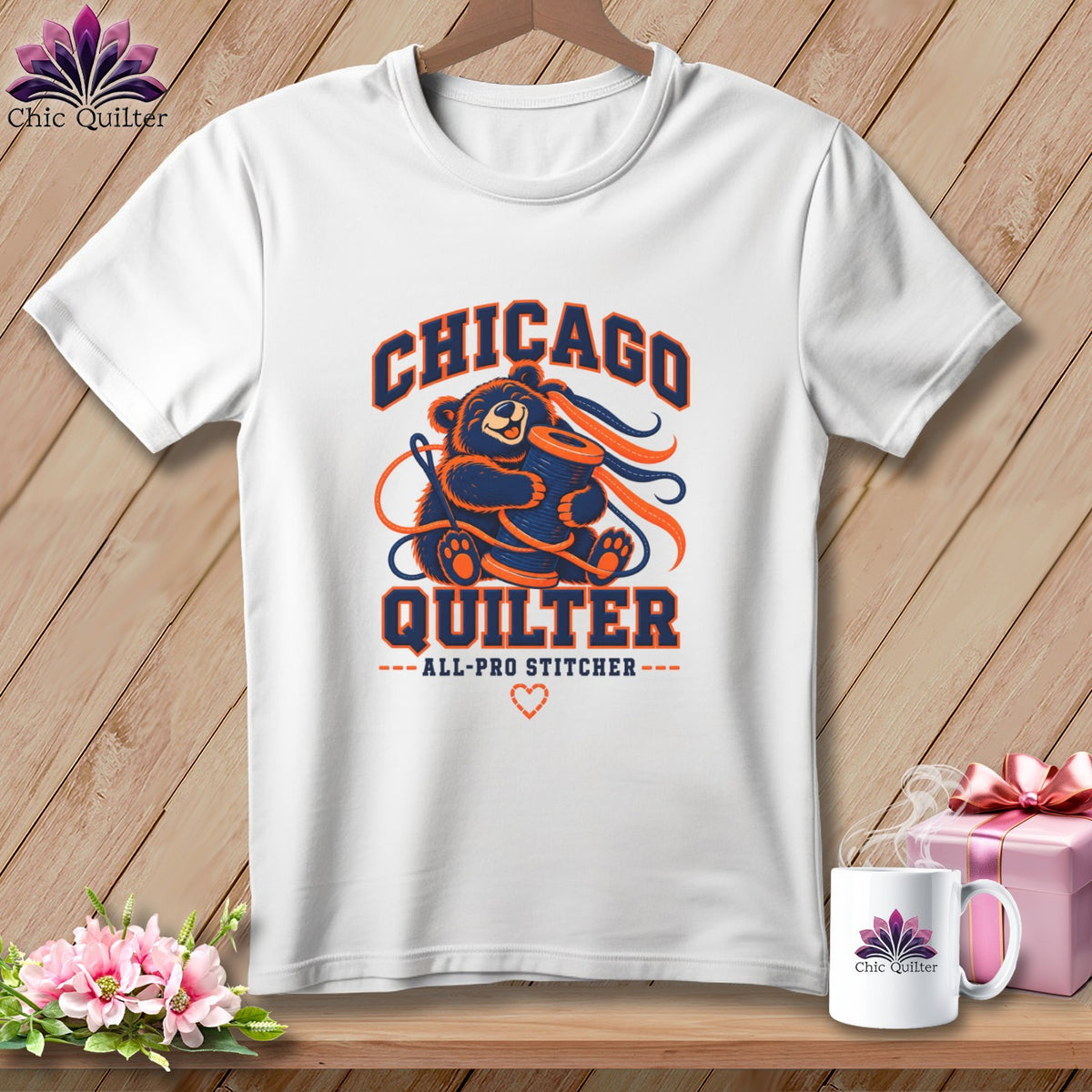 White t-shirt with a blue and orange Chicago Quilter graphic featuring a bear holding a spool.