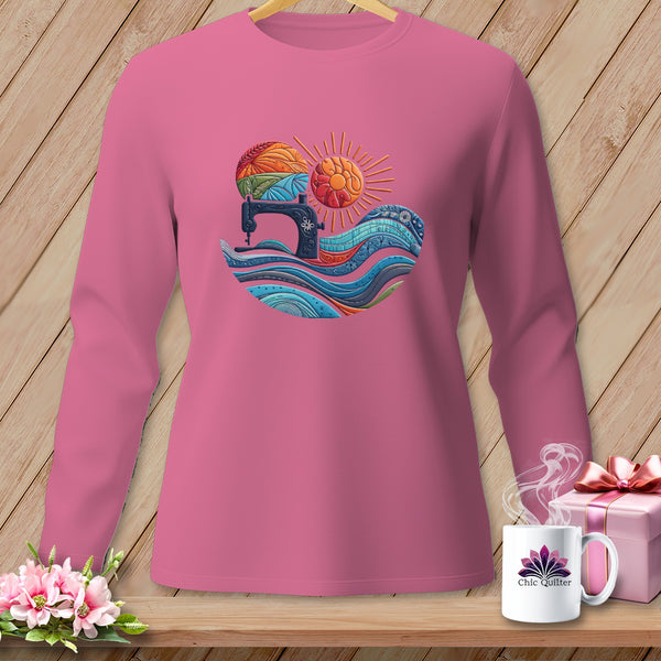 Pink long-sleeve shirt with a graphic of a sewing machine and colorful waves.