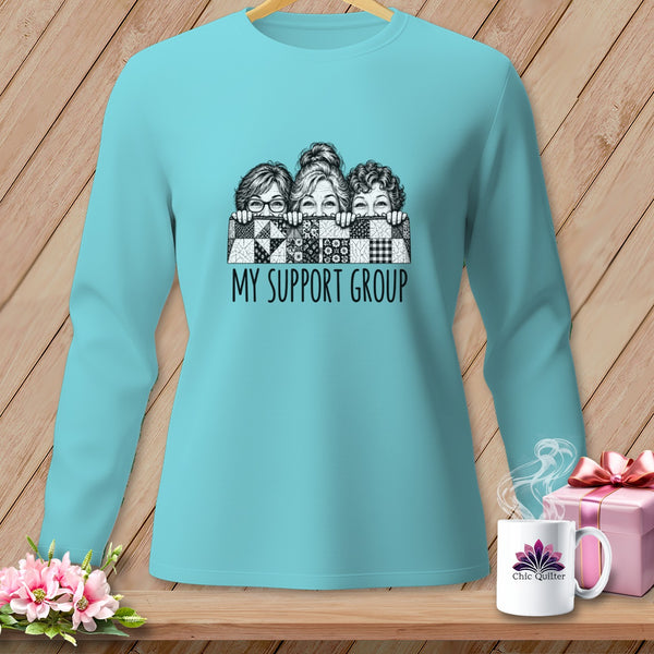 Teal long-sleeve shirt with graphic of three women peeking over quilt, text reads "MY SUPPORT GROUP".