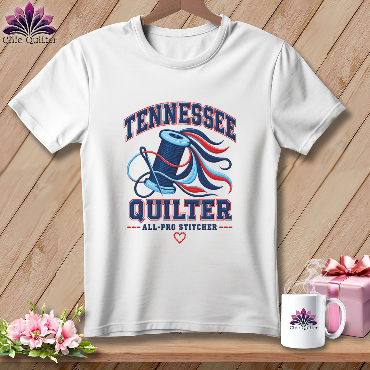 A white t-shirt featuring a blue spool of thread, a needle, and the text Tennessee Quilter.