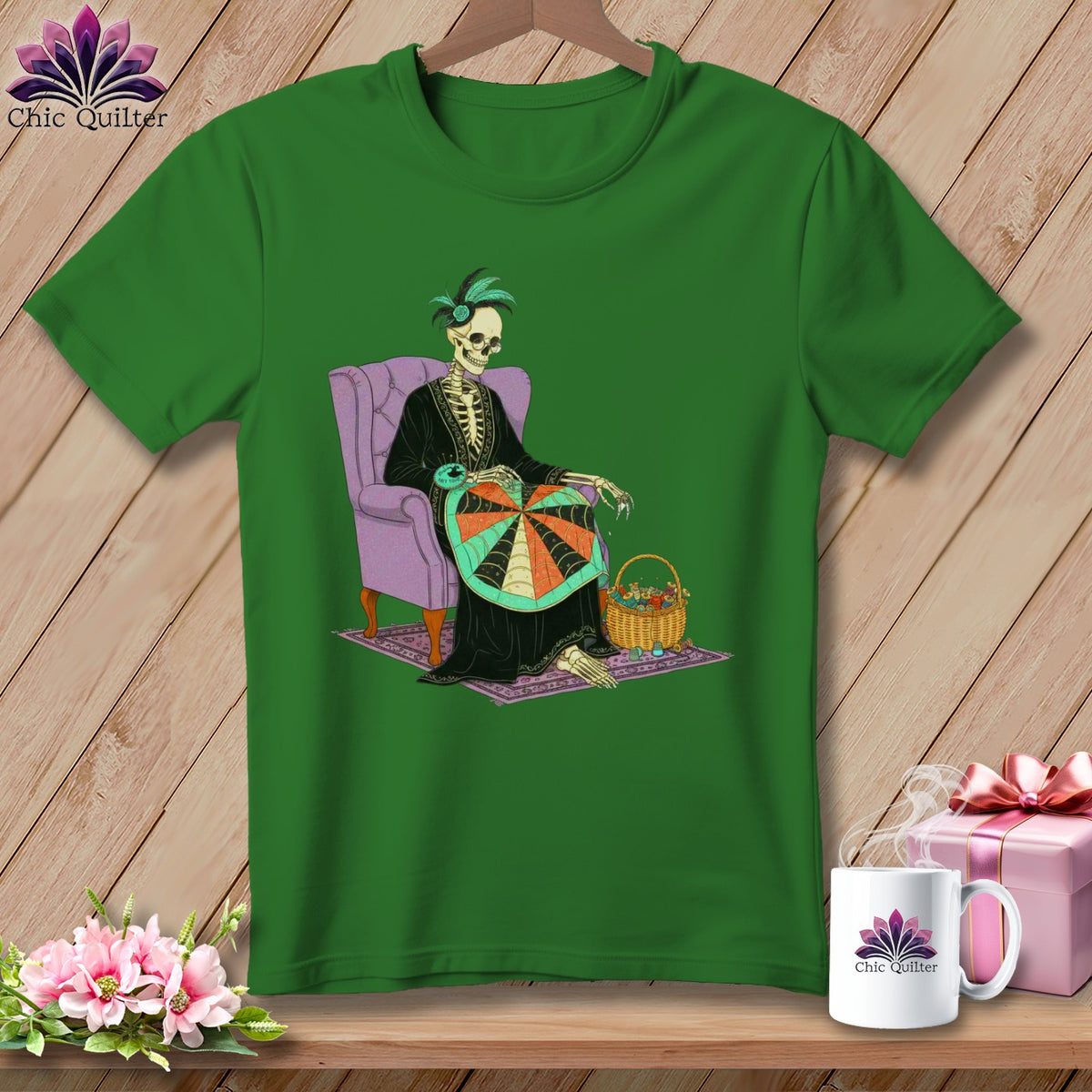 Skeleton in a chair knitting a colorful spiderweb design on a green t-shirt.