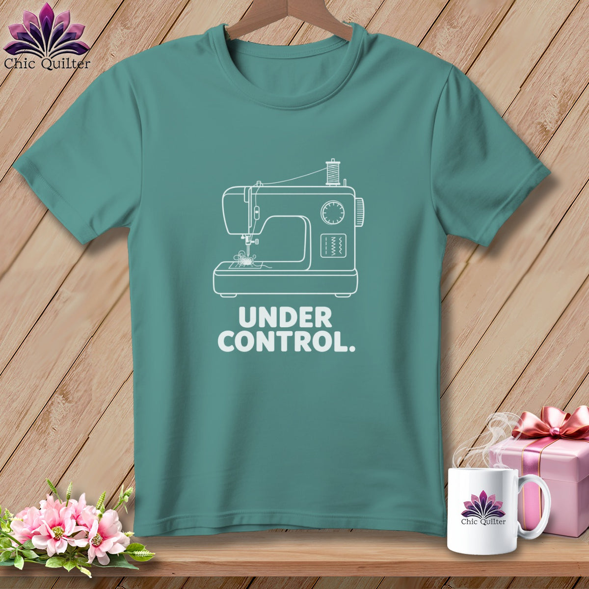 Teal t-shirt with white sewing machine graphic and "UNDER CONTROL." text.