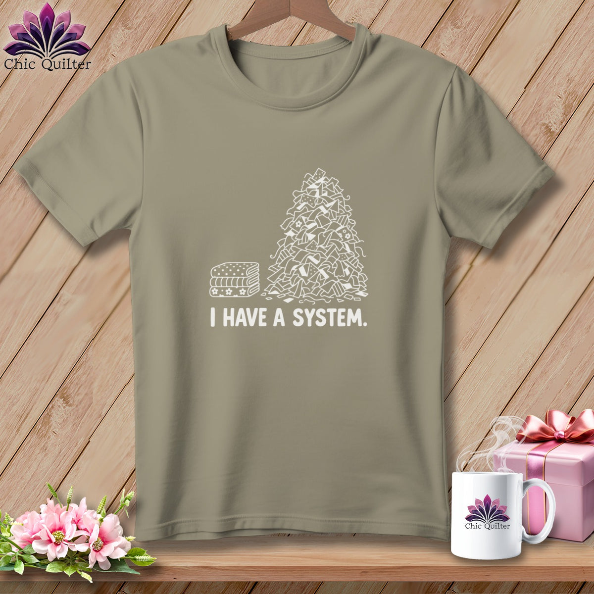 T-shirt with a pile of fabric scraps and stacked fabric labeled "I HAVE A SYSTEM."