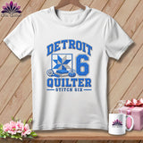 White t-shirt featuring blue Detroit Quilter graphic with quilt block, rotary cutter, and number six.