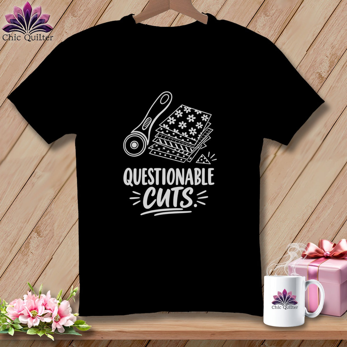 Black t-shirt with white graphic of rotary cutter, fabric squares, and text "Questionable Cuts".