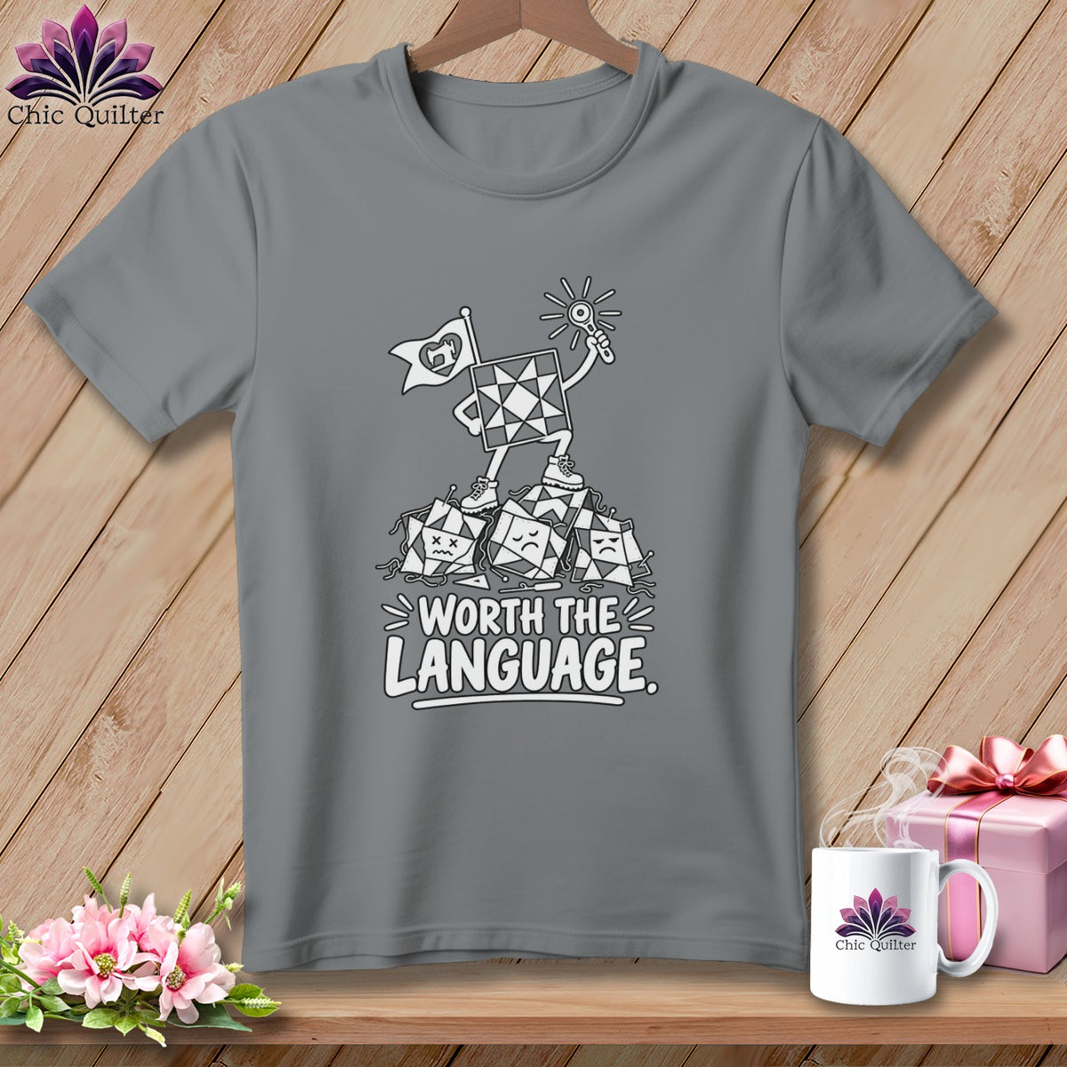 Gray t-shirt featuring a quilt block character standing on a pile of sad quilt blocks with text "WORTH THE LANGUAGE."