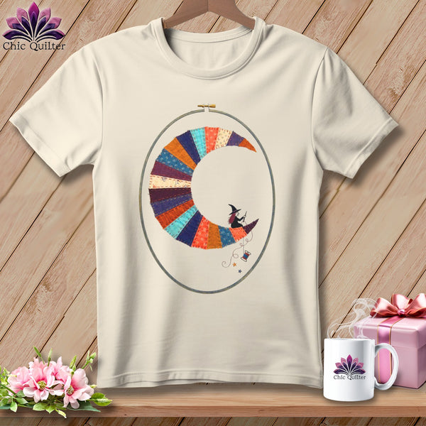 Cream t-shirt with a crescent moon made of colorful fabric patches and a witch riding it.