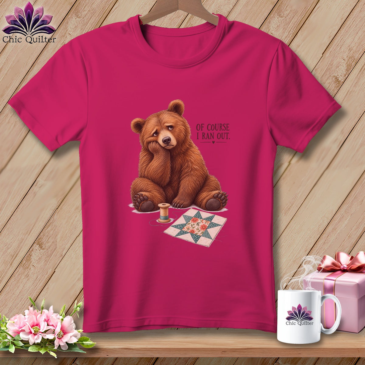 Pink t-shirt with a sad bear, quilt block, and spool of thread.