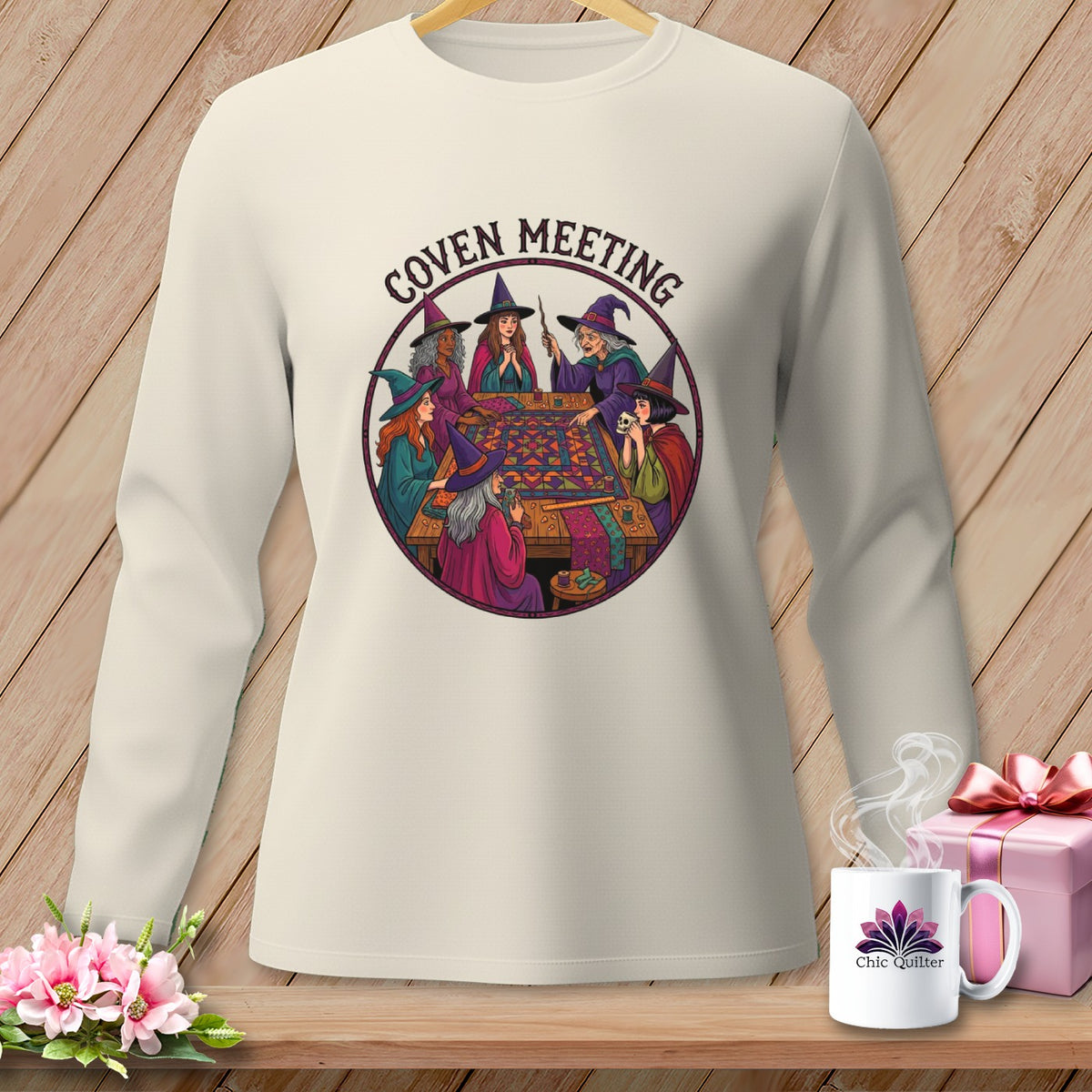 Long sleeve shirt with "Coven Meeting" graphic of witches sewing a quilt.
